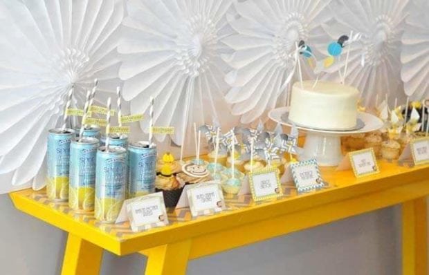 The Curious George dessert table features lots of treats in the blue, yellow, and white color scheme.