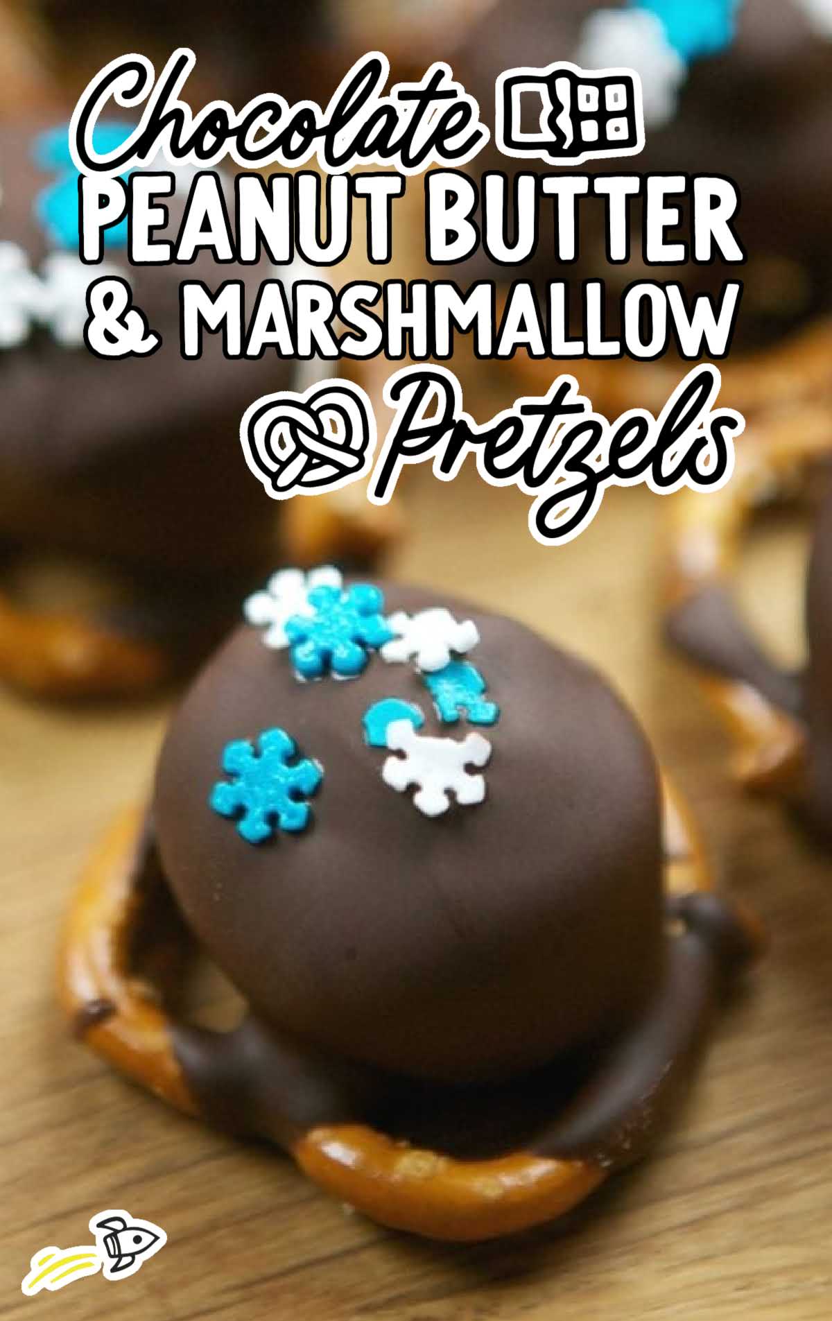 Close-up of a chocolate-dipped peanut butter and marshmallow pretzel topped with blue and white snowflake sprinkles.