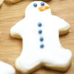 A wooden cutting board, with Gingerbread and Snowman