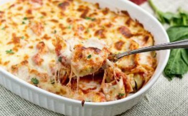 A pizza sitting on top of a plate of food, with Tortellini