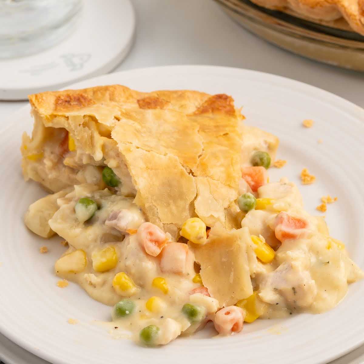 Close-up of chicken pot pie slice on a white plate with text overlay reading Chicken Pot Pie Recipe
