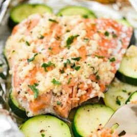 close up shot of a cooked salmon placed on top of sliced zucchini