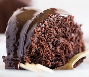A close up of a piece of chocolate cake on a plate, with Red Wine