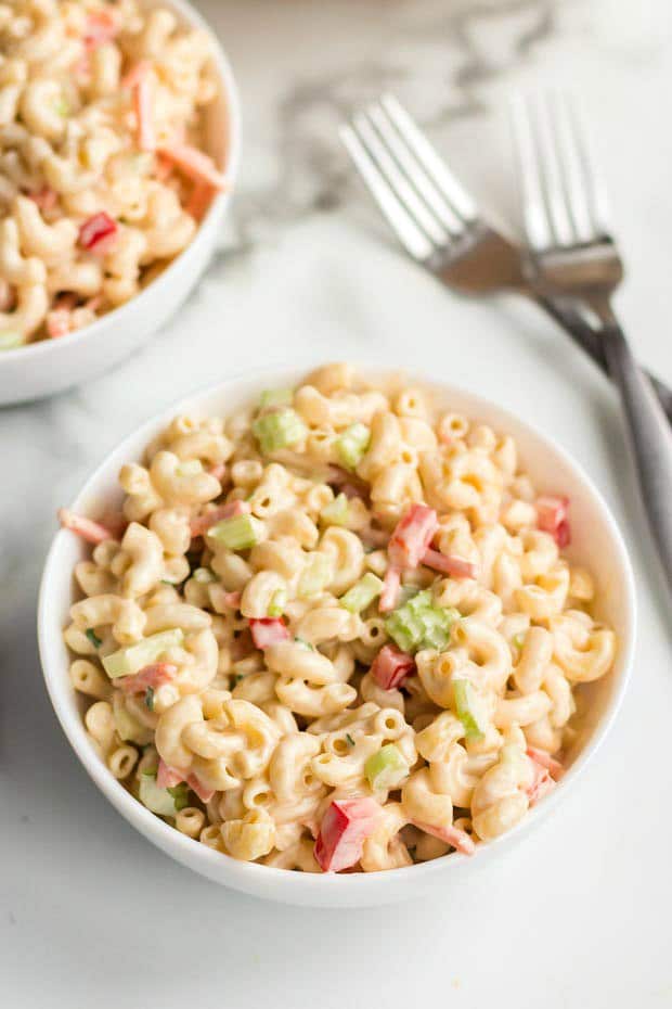 A bowl of rice on a plate, with Salad and Macaroni