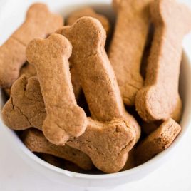close up shot of homemade dog treats piled in a white bowl
