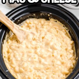 close up shot of Crockpot Mac and Cheese in a crockpot with a large wooden spoon