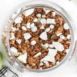 close up overhead shot of apple cinnamon granola in a mason jar and on a spoon