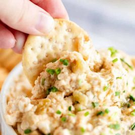 A piece of food, with Crab dip and Cracker