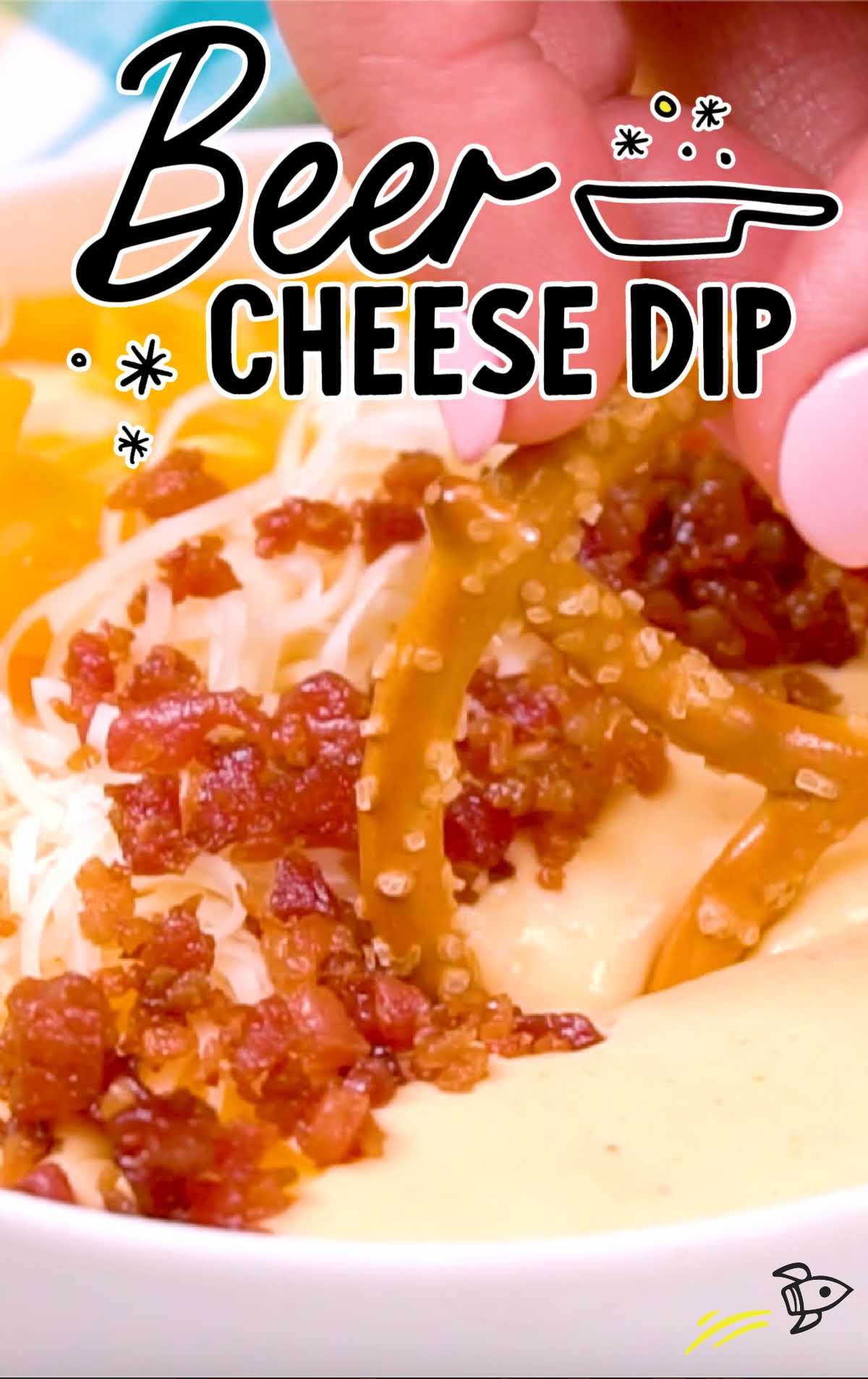 close up shot of a pretzels dipped into a condiment bowl of Beer cheese dip topped with shredded cheese and bacon bits