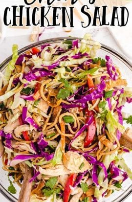 close up shot of Chinese chicken salad in a bowl with tongs