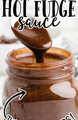 side shot of hot fudge sauce being poured with a spoon into a mason jar