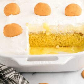 close up shot of Banana Pudding Cake topped with a vanilla wafer in a dish