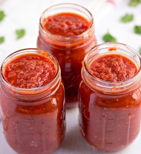 A glass of orange juice, with Sauce and Tomato