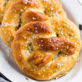 close up shot of homemade soft pretzels topped with kosher salt on a plate