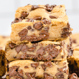 chocolate chip cookie bars stacked on top of each other with chocolate chips melting