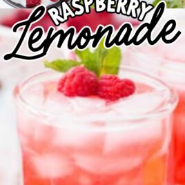 a glass of Raspberry Lemonade topped with raspberries and mint