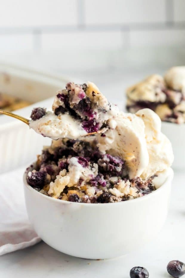 Ein Dessert auf einem Teller, mit Cobbler und Blaubeeren