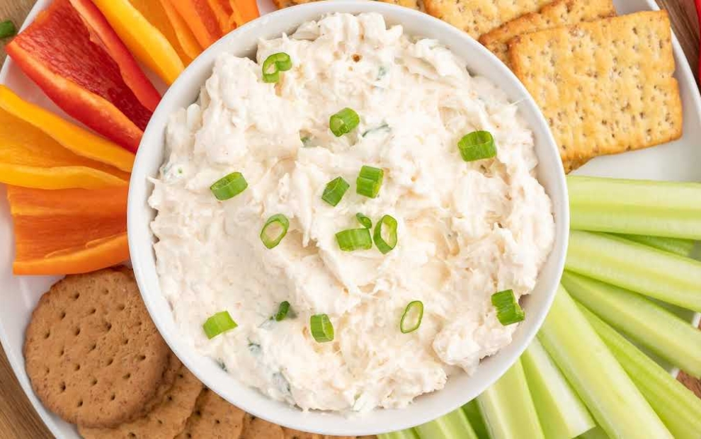 a bowl of Crab Dip topped with chopped green onions