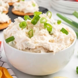 a bowl of Crab Dip topped with chopped green onions