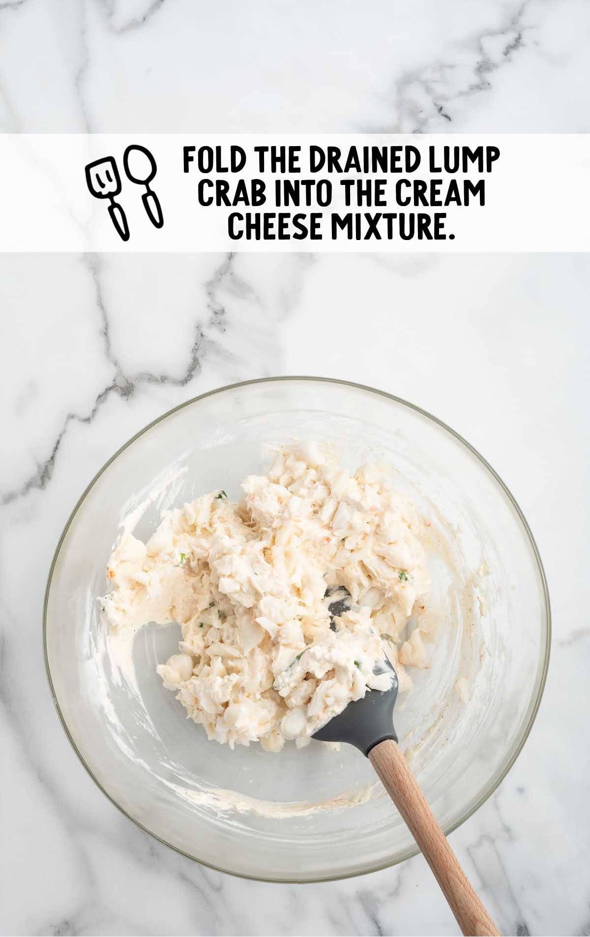 drained lump crab meat folded into the ingredients in the bowl