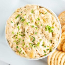 overhead shot of a bowl of Hot Crab Dip garnished with chives