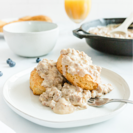 country biscuits and sausage gravy on a white plate