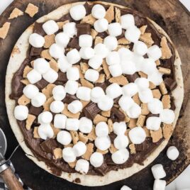 close up overhead shot of a chocolate dessert pizza on a wooden board