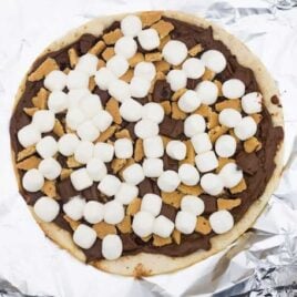 close up shot of a chocolate dessert pizza on top of aluminum foil