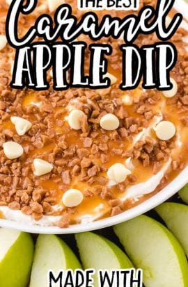 close up overhead shot of a bowl of caramel apple dip topped with caramel, toffee, and white chocolate with sliced apples on the side for dipping