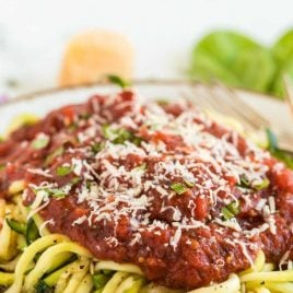 close up shot of a plate of Zucchini Noodles served with salsa and parmesan cheese on top
