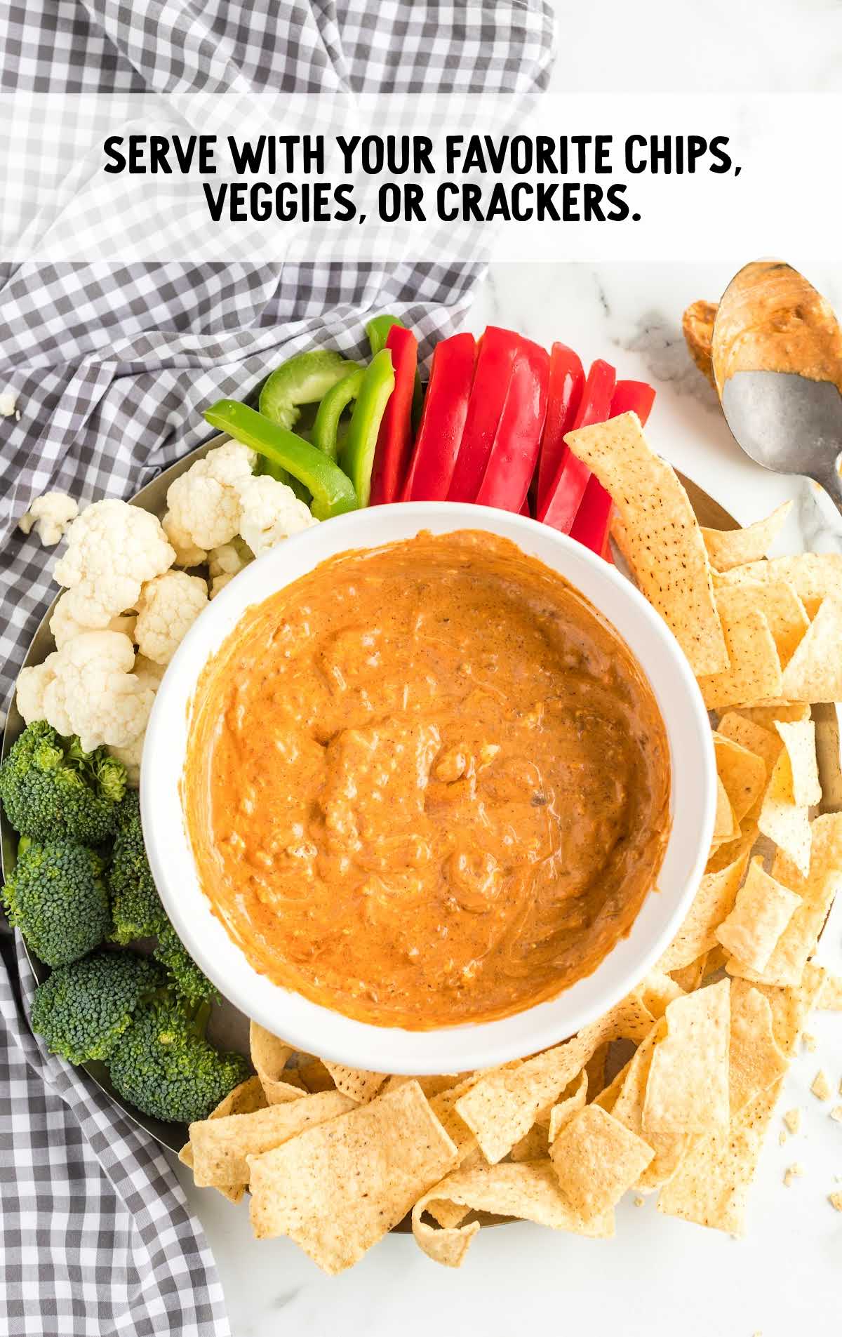 chili cheese dip served with chips and veggies