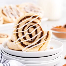 a close up shot of a Cinnamon Roll Cookie with a bite taken out of it on a plate