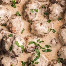 close up overhead shot of a crockpot full of meatballs garnished with parsley