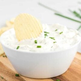 close up shot of French Onion Dip in a white bowl with a chip