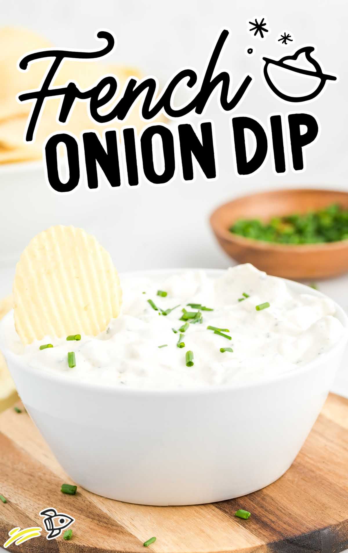 close up shot of French Onion Dip in a white bowl with a chip