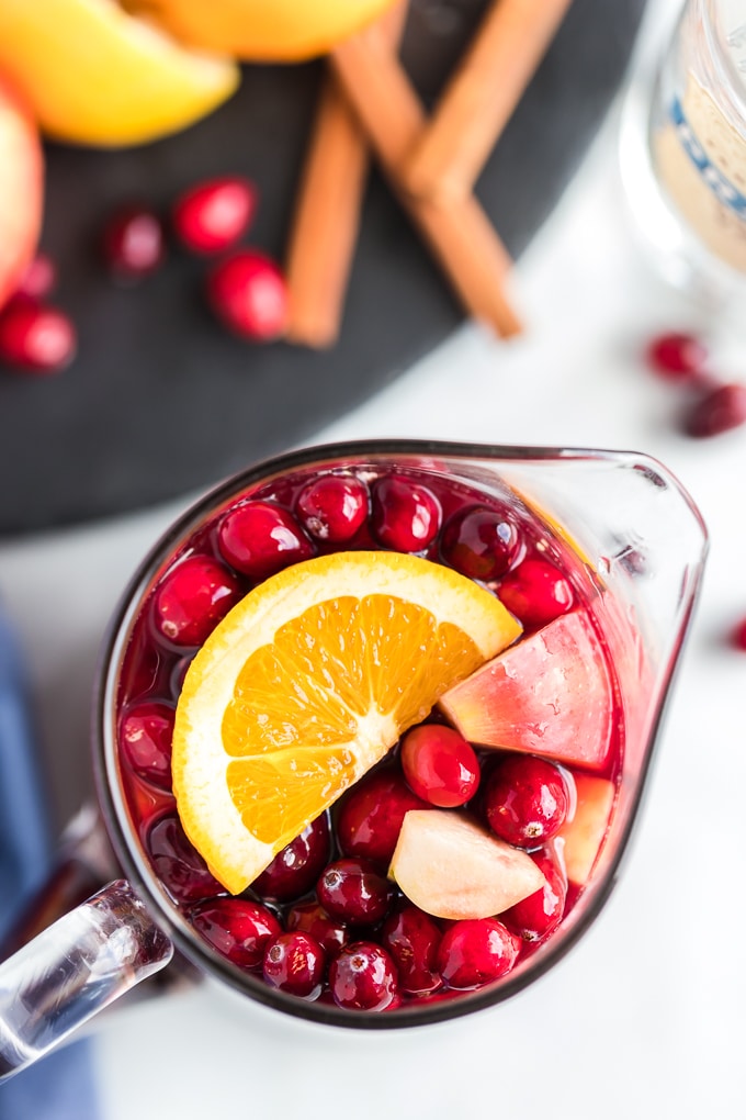 A bowl of fruit on a plate, with Sangria and Juice