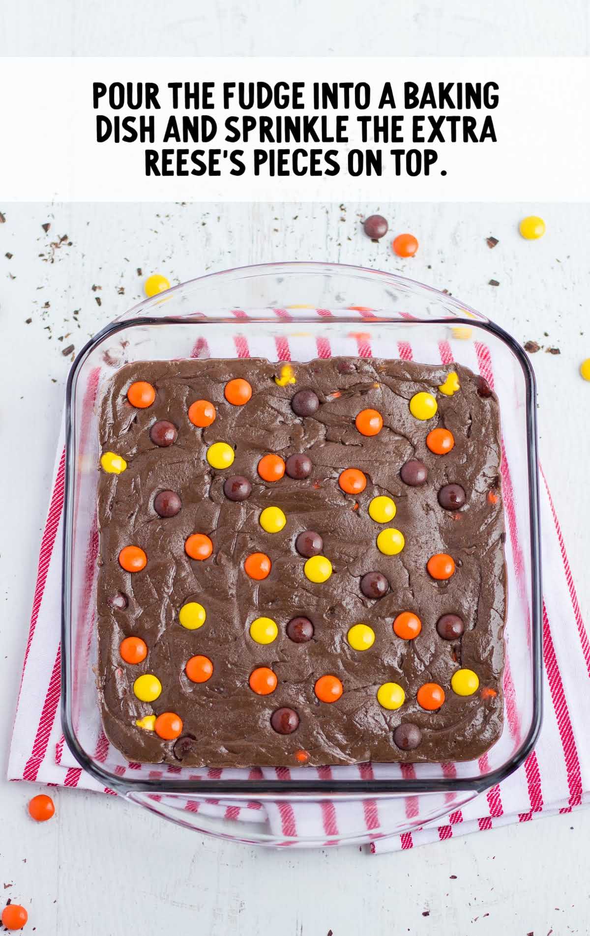 fudge poured into the baking dish and reeses's pieces sprinkled on top