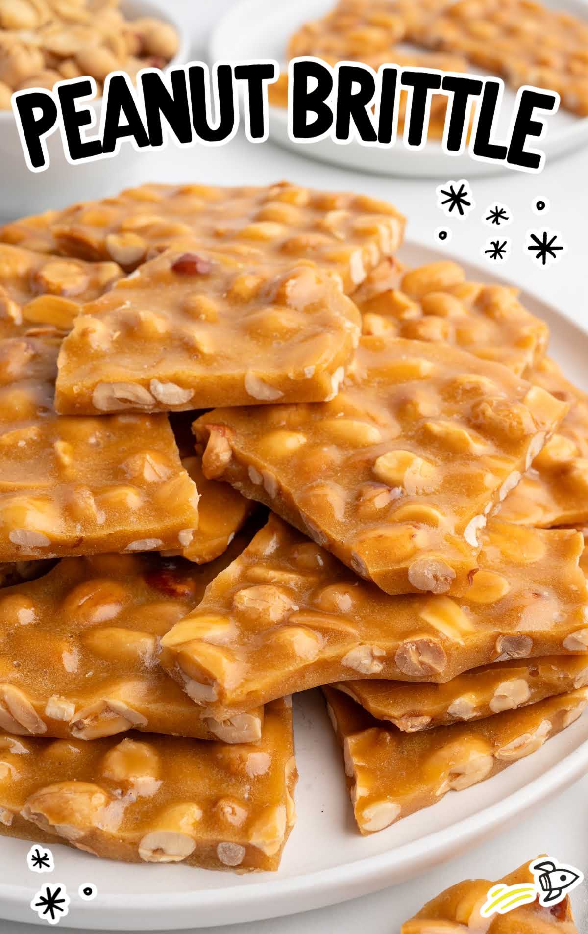 Plate of peanut brittle pieces with text overlay reading Peanut Brittle