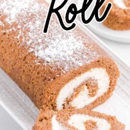 close up shot of pumpkin roll with a slice removed on a serving tray