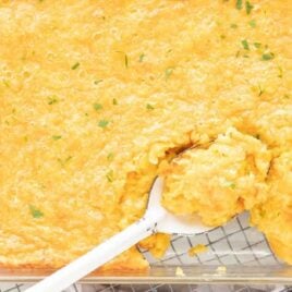overhead shot of Corn Casserole on a baking dish with a spoon taking out a piece