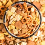 close up overhead shot of a bowl of Crockpot Chex Mix surrounded by Crockpot Chex Mix