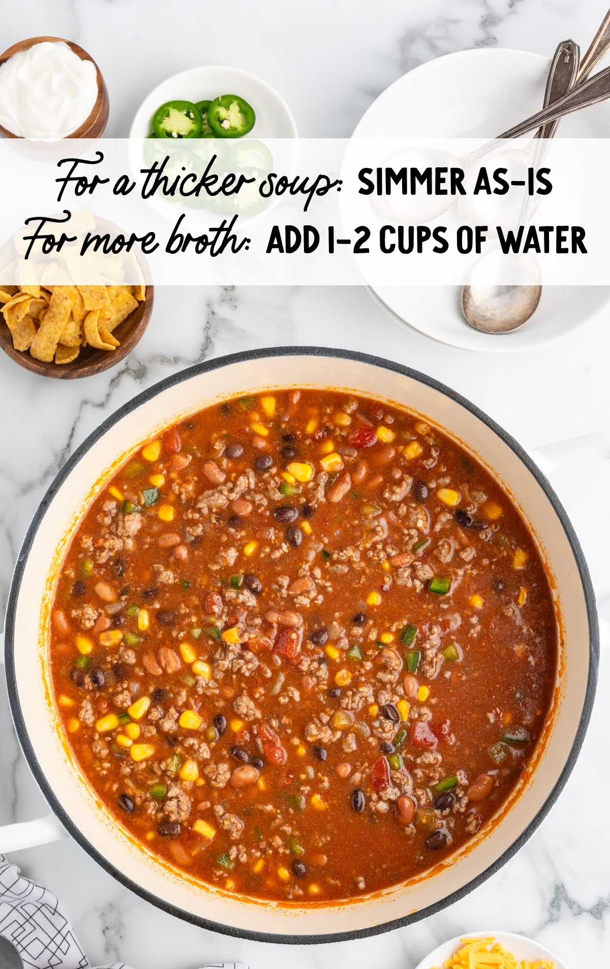 Overhead shot of soup simmering in a large pot with a text overlay providing options for adjusting soup thickness by adding water.