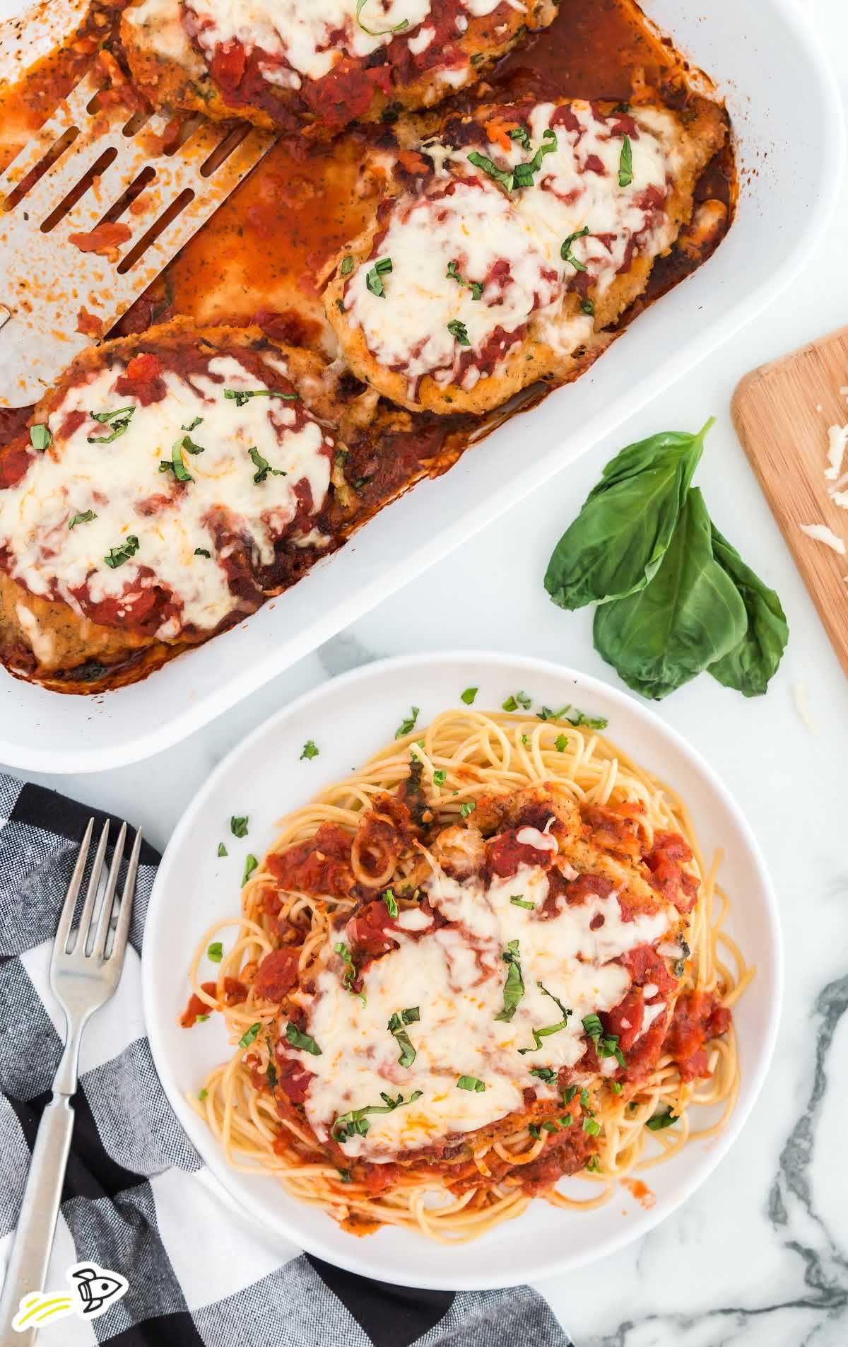 close up of chicken parmesan served over spaghetti