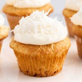 Coconut Cupcakes topped with frosting a coconut flakes