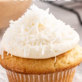 a Coconut Cupcake topped with frosting a coconut flakes