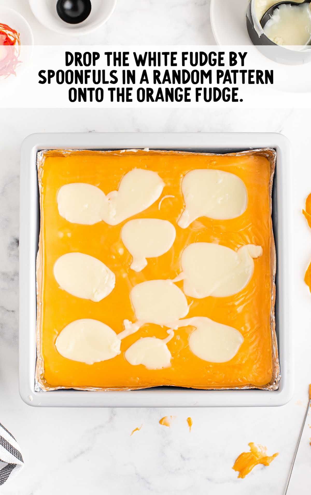 white fudge dropped in random patterns on top of the orange fudge