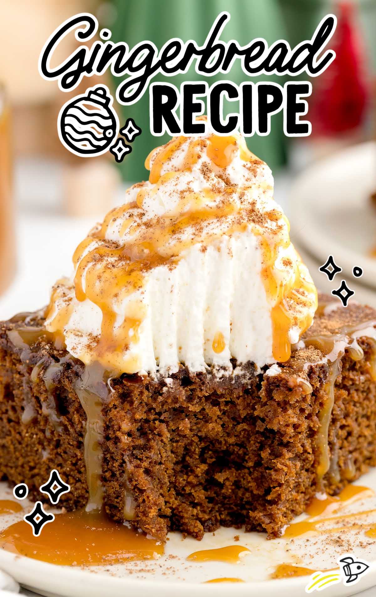 close up shot of a slice of Gingerbread topped with whipped cream and drizzled with caramel syrup on a plate