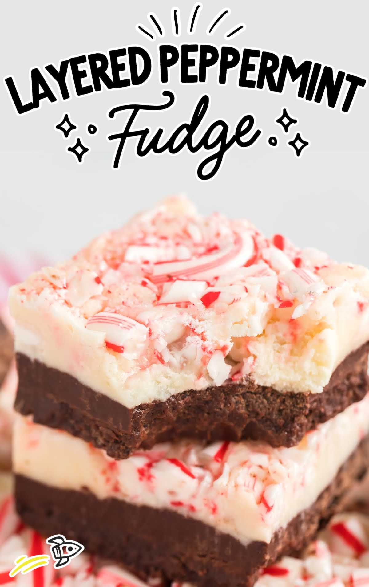 A close up shot of Layered Peppermint Fudge stacked on top of each other with one having a bite taken out of it