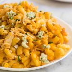 close up shot of a serving of Buffalo Chicken Mac and Cheese garnished with parsley on a plate