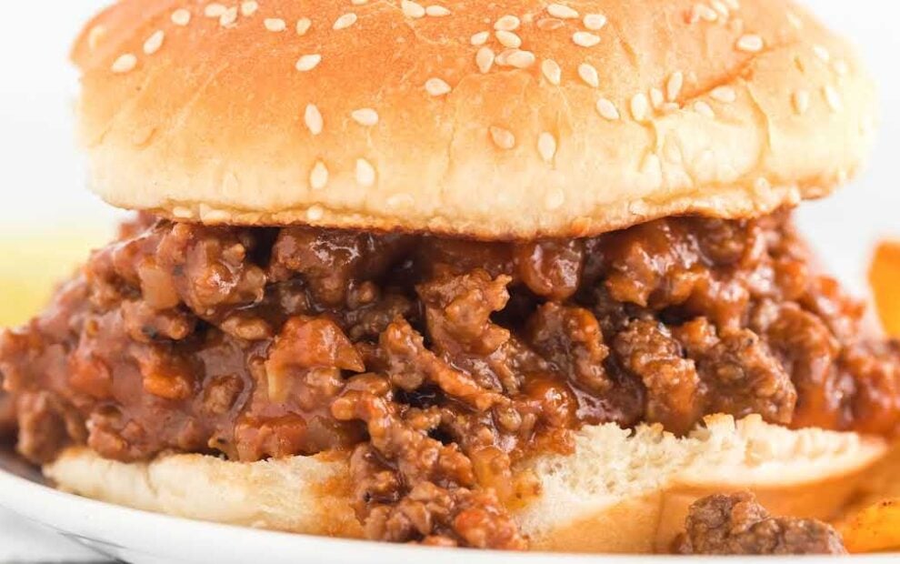 close up shot of a sloppy Joe sandwich on a plate with chips